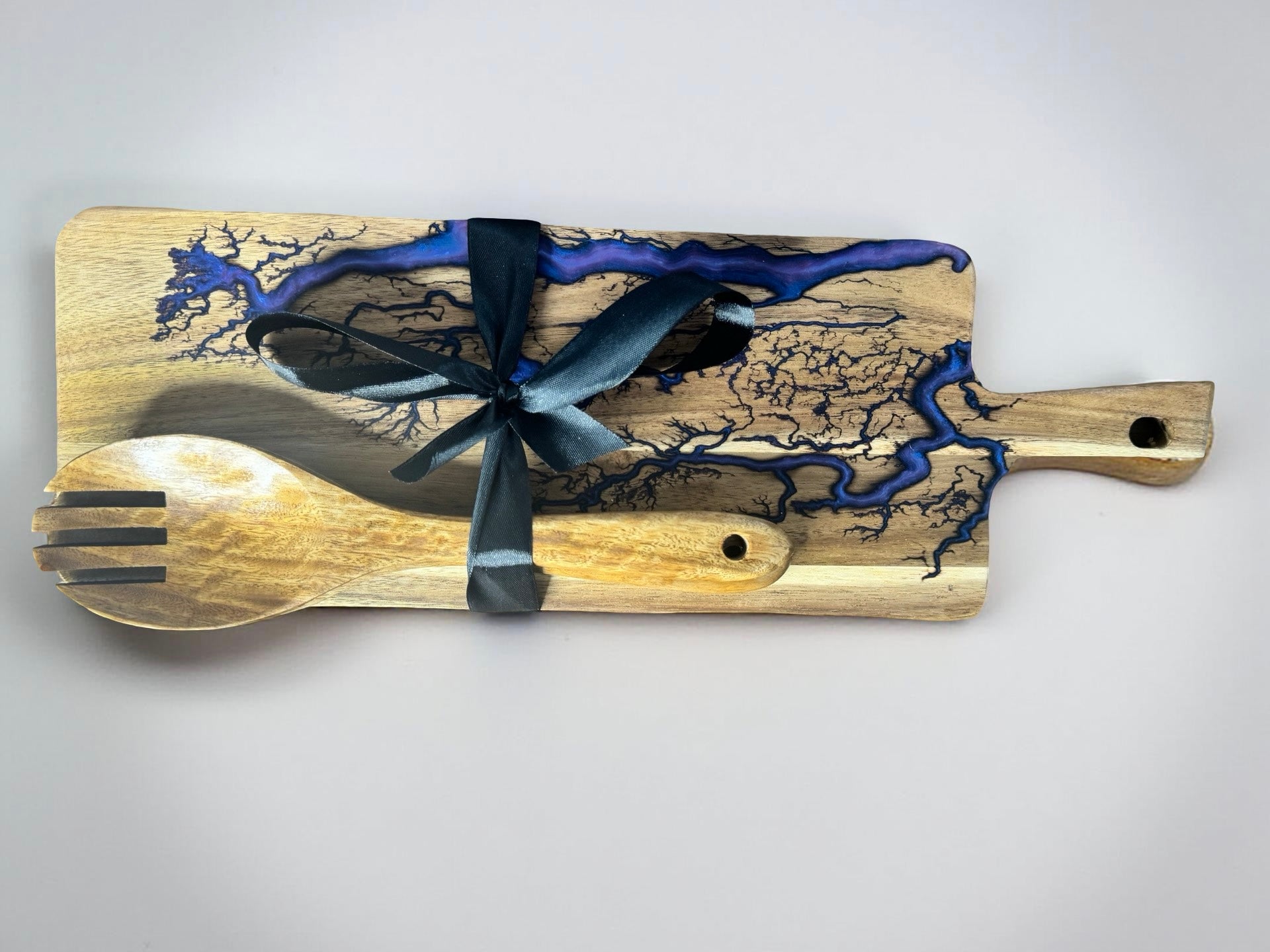 Rectangle Cheese board with purple resin artwork which is resin inlayed after a fractal burning process and pair with 2 wooden utensils made from teak wood making a fantastic gift set made in australia