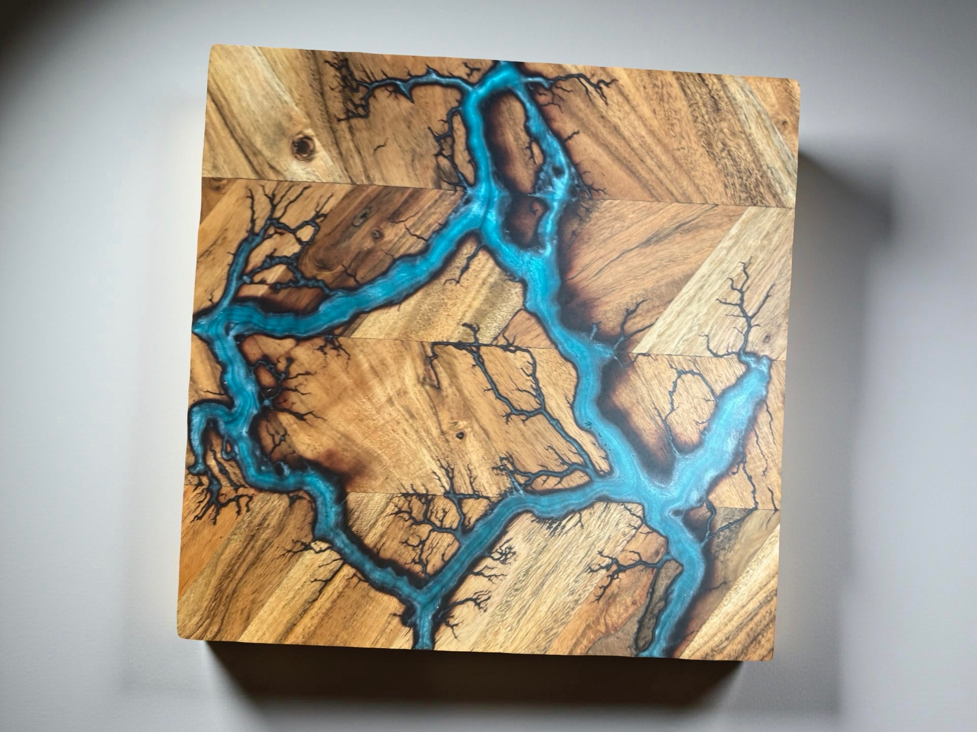fractal burning art on acacia chopping board inlayed with lagoon blue  resin , made by fractal flow designs , premium resin boards Australia